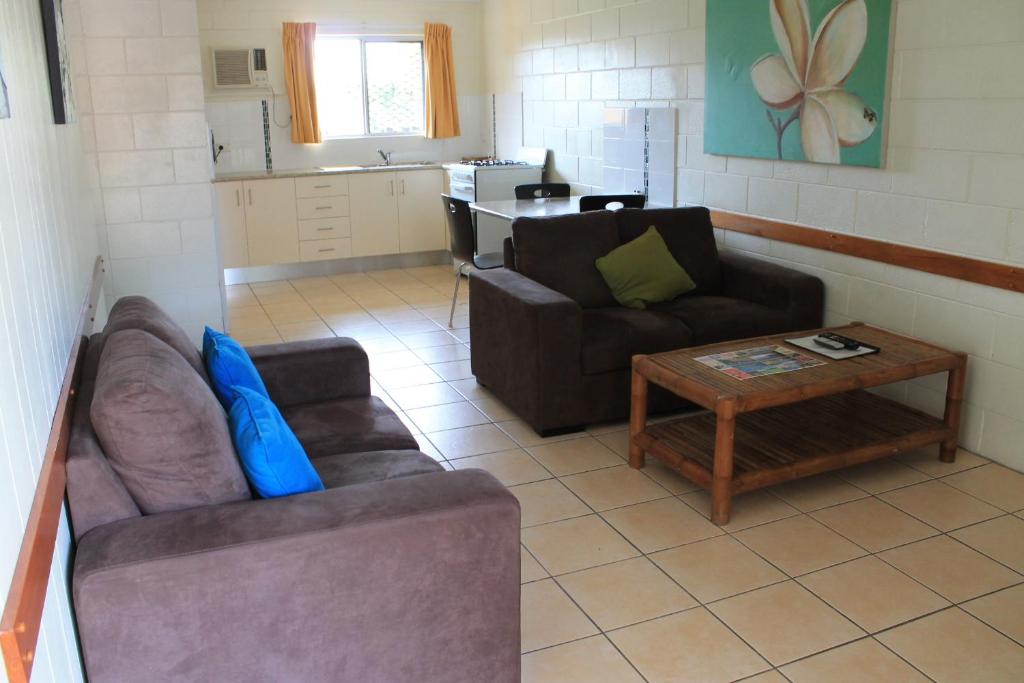a living room with two couches and a coffee table at Oasis Inn Apartments in Cairns