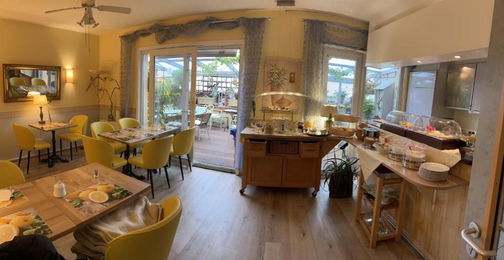 a dining room with tables and yellow chairs at Hotel Löhndorf in Bonn