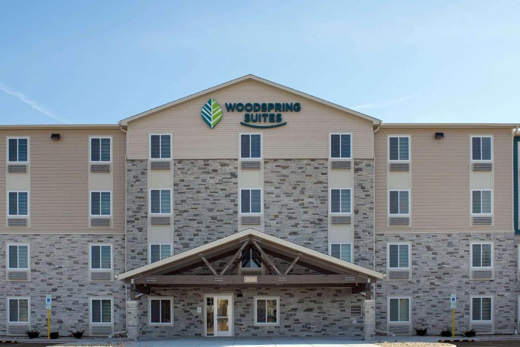 a large building with a sign on top of it at WoodSpring Suites Chicago Tinley Park in Tinley Park