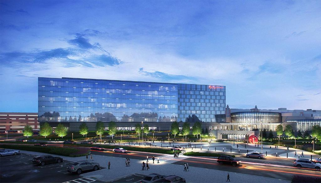 皇后區的住宿－Hyatt Regency JFK Airport at Resorts World New York，一座大型玻璃建筑,停车场内有车辆停放