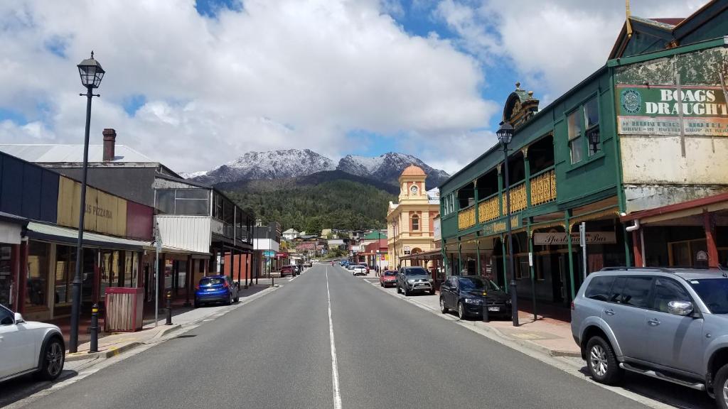 een straat in een stad met een berg op de achtergrond bij Hunters Hotel in Queenstown