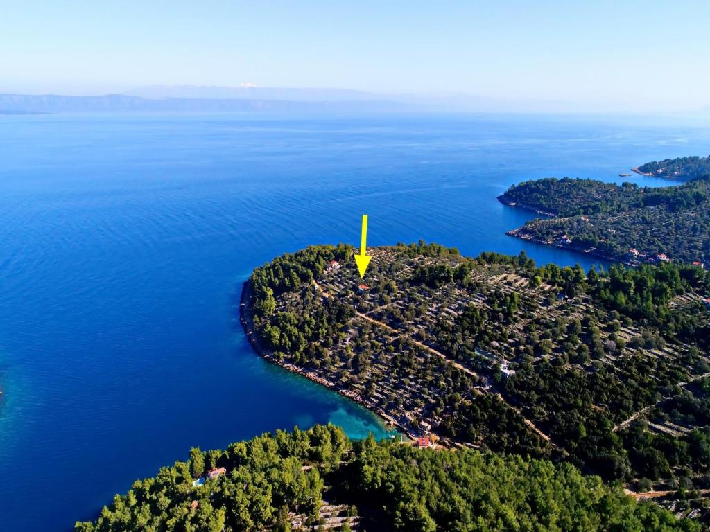 une île dans l'eau avec un marqueur jaune sur elle dans l'établissement Green Area Stone House, à Vela Luka