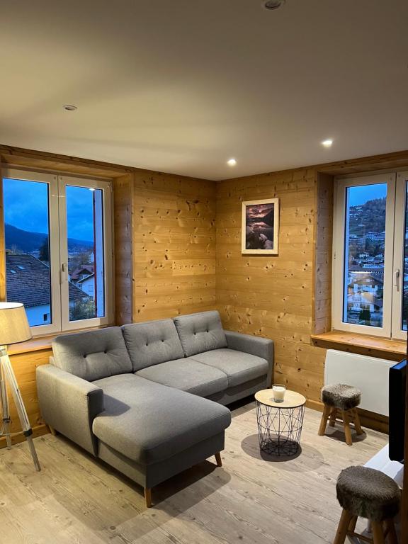 a living room with a couch and some windows at Chez Léa et Lolo - Le Nordique in Gérardmer