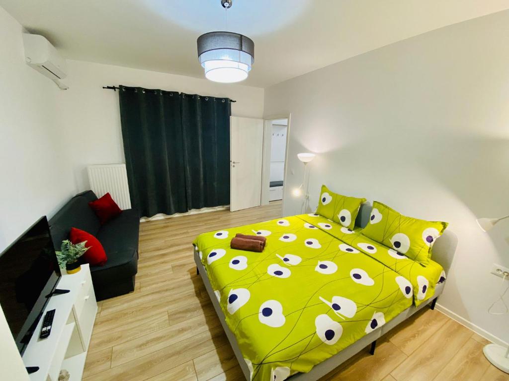 1 dormitorio con cama amarilla y sofá en Plaza Residence Studio 2, en Bucarest
