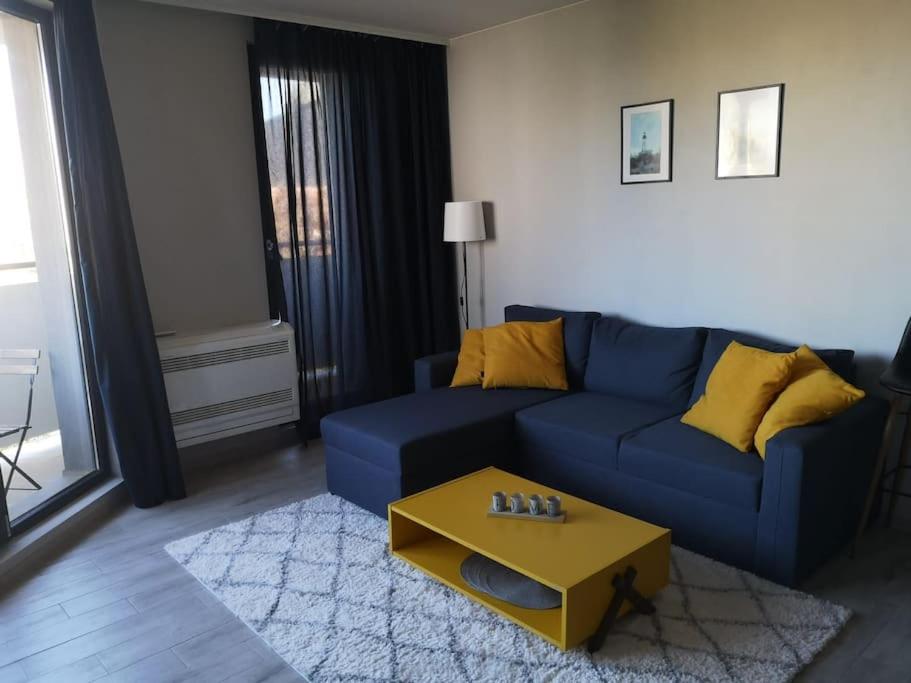 a living room with a blue couch and a coffee table at Apartment Opalchenska / Pirotska in Sofia