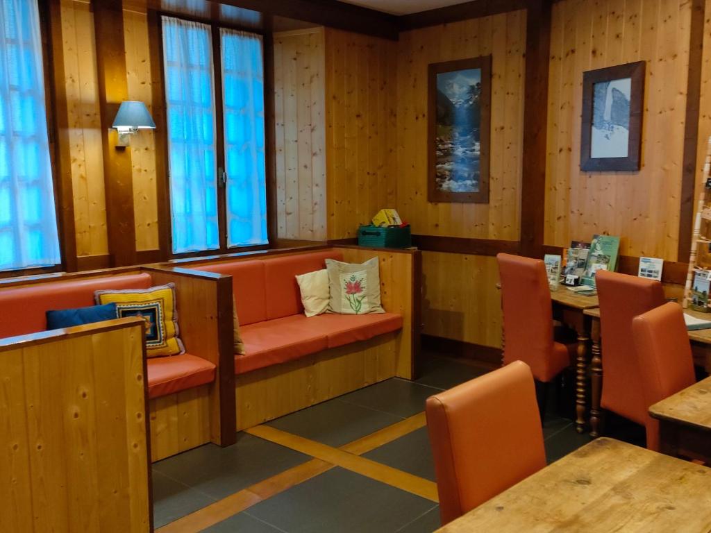 un restaurant avec des chaises orange, des tables et des fenêtres dans l'établissement Gîte Beau Soleil, à Cauterets