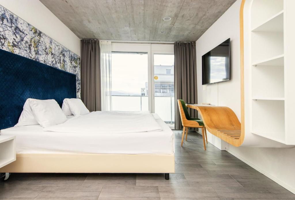 Postel nebo postele na pokoji v ubytování Tailormade Hotel IDEA Spreitenbach