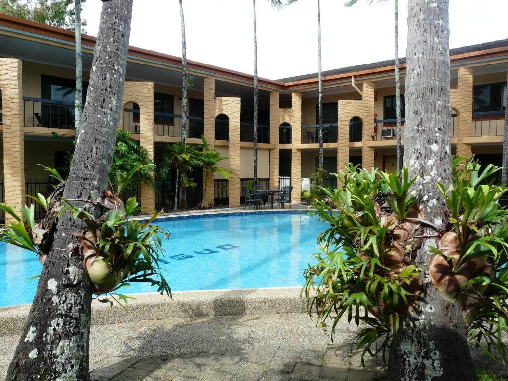 a swimming pool in front of a building at Oasis Inn Apartments in Cairns