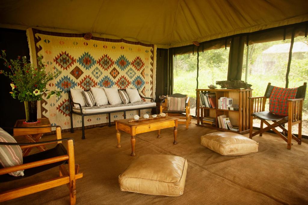 a living room with a couch and chairs in a tent at Esirai Camp in Sinoni