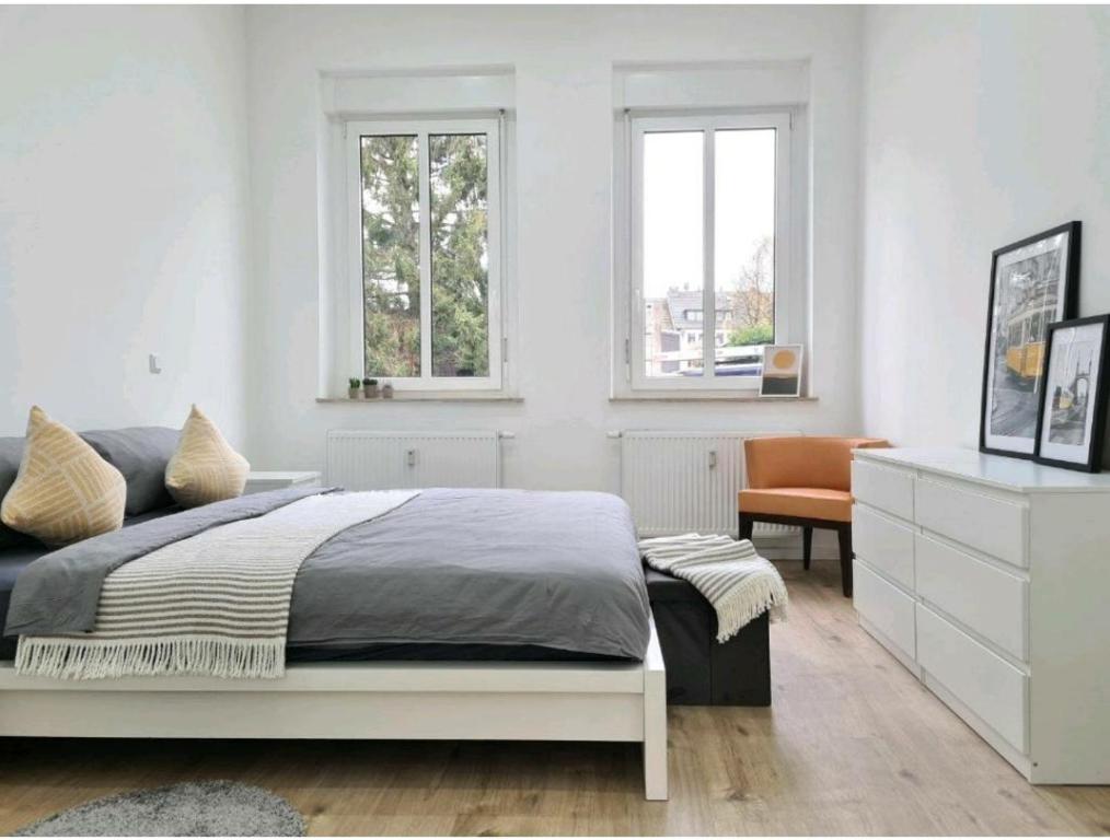 1 Schlafzimmer mit einem Bett, einem Schreibtisch und 2 Fenstern in der Unterkunft Ihr zu Hause auf Zeit! in Solingen