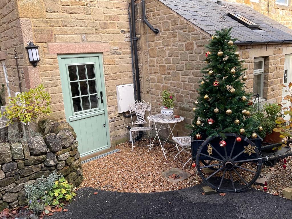 a christmas tree on a cart in front of a house at Carr’s cottage Eyam Peak District, in Eyam