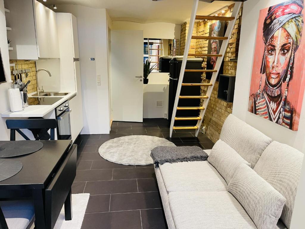 a living room with a couch and a kitchen at Studio Apartment in the heart of Aalborg in Aalborg
