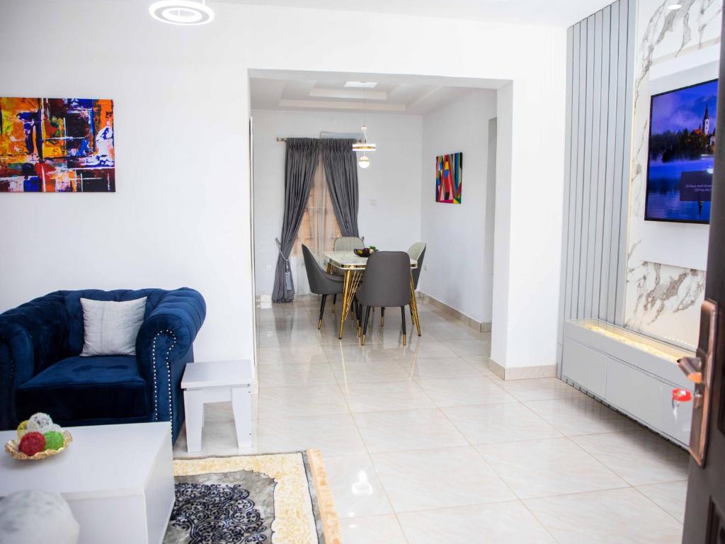 a living room with a blue couch and a table at Delight Apartments in Lagos