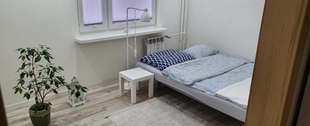 małe łóżko w małym pokoju z oknem w obiekcie Apartament Busko-Zdrój - Franio w Busku Zdroju