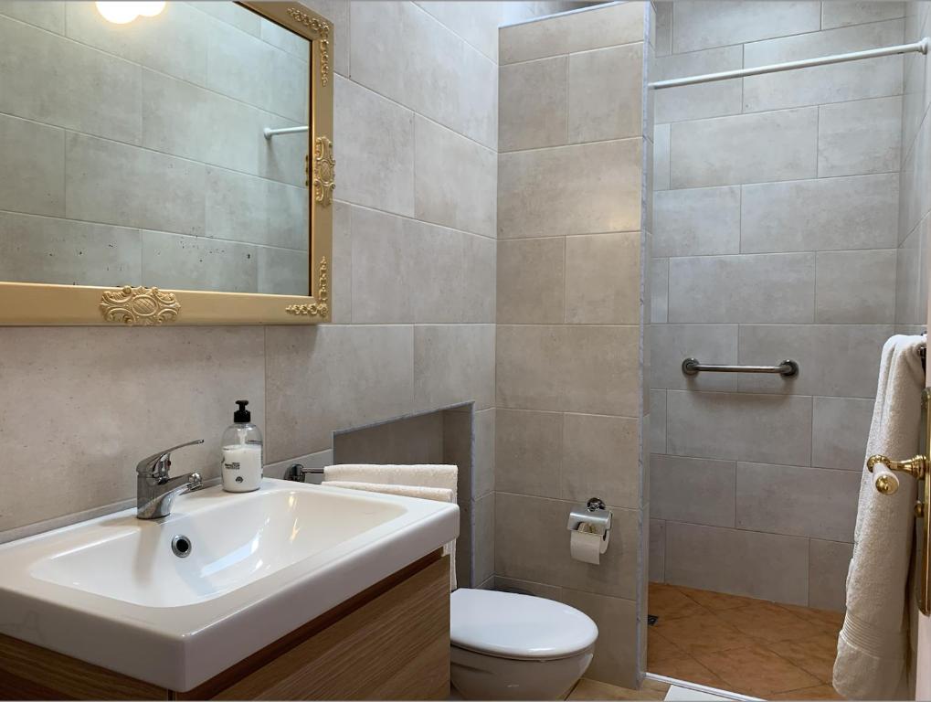 een badkamer met een wastafel, een toilet en een spiegel bij Casa Jasmin Haria in Haría