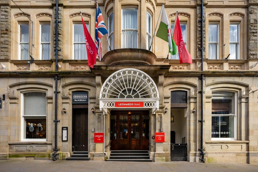 un edificio con banderas en la parte delantera en Leonardo Hotel Cardiff en Cardiff