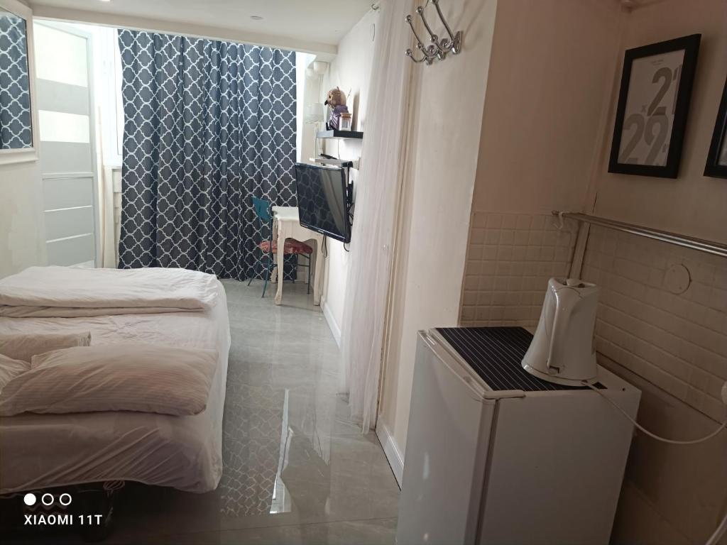 una piccola camera con letto e televisore di bugrashov 13 room a Tel Aviv