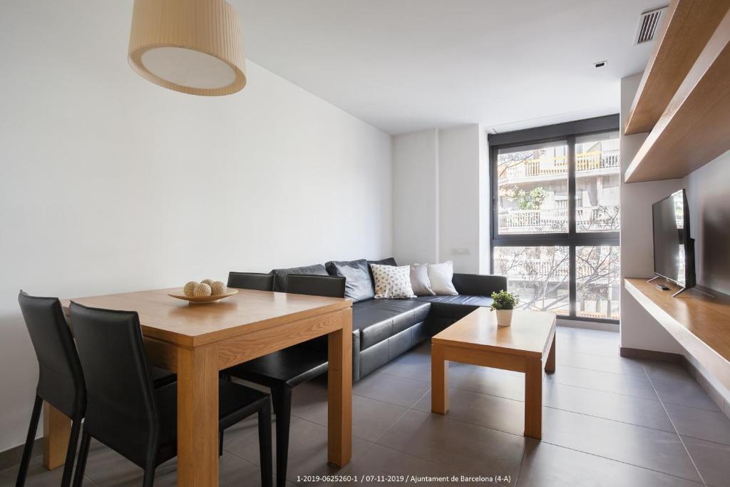 ein Wohnzimmer mit einem Tisch und einem Sofa in der Unterkunft Flateli Navas D01 in Barcelona
