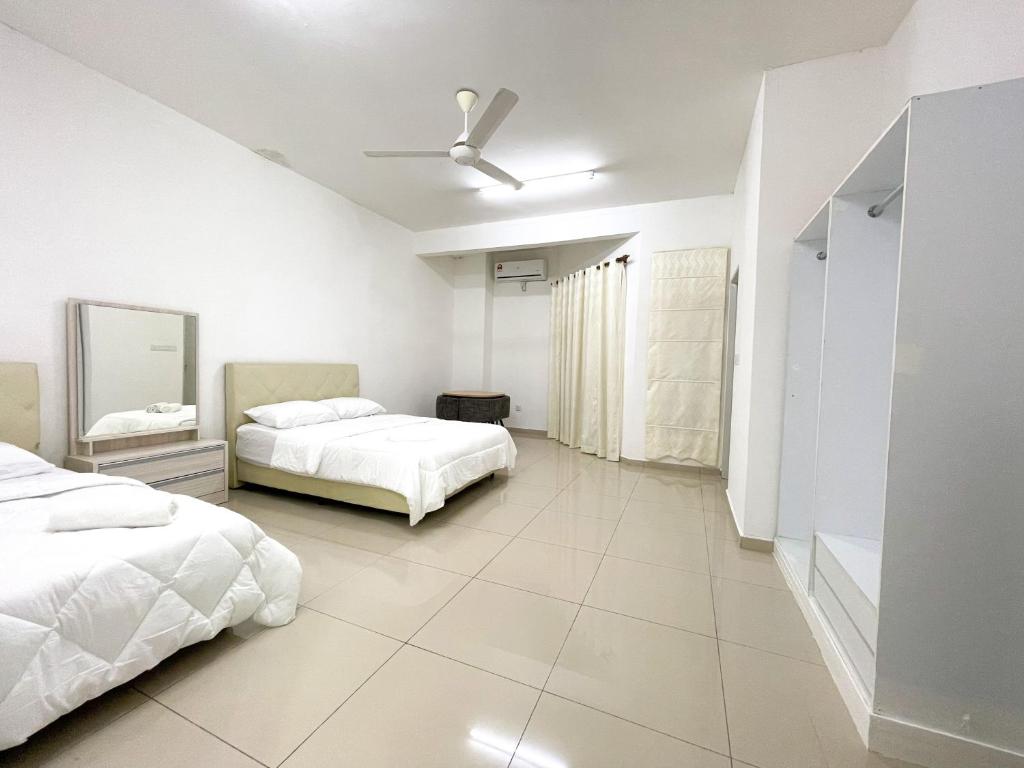 - une chambre avec 2 lits et un ventilateur de plafond dans l'établissement Muslim Homestay Raudhatul Jannah Bandar Sri Sendayan, à Seremban