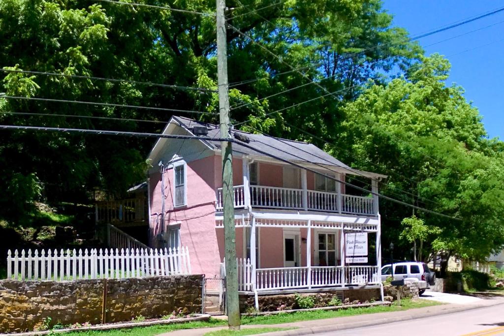 a pink and white house with a white fence at The Pink House on Main - Lower in Eureka Springs