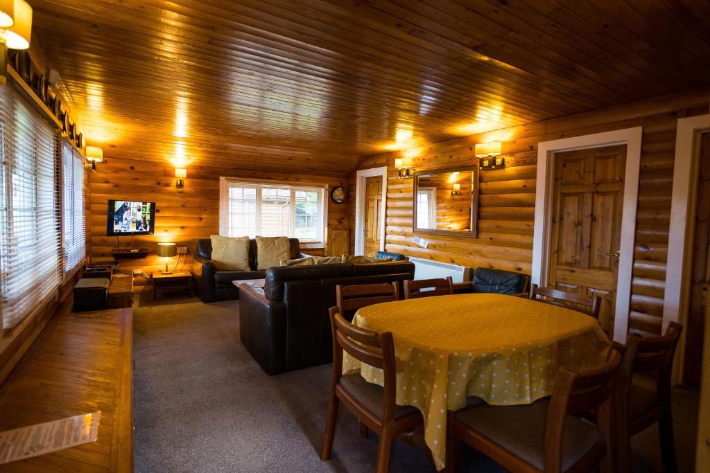 uma sala de estar com uma mesa e um sofá em Mountain View Log Cabin - Wales em Trawsfynydd