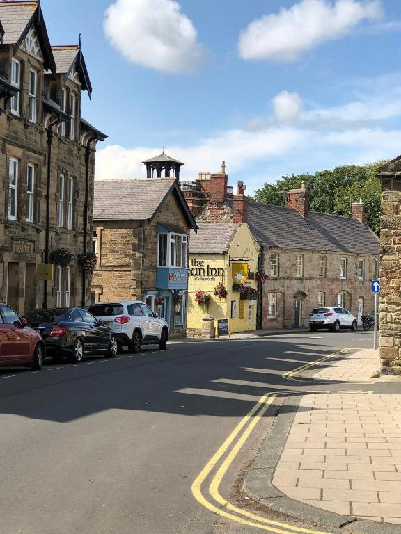 a city street with cars parked on the side of the road at The Sun Rooms in Alnmouth