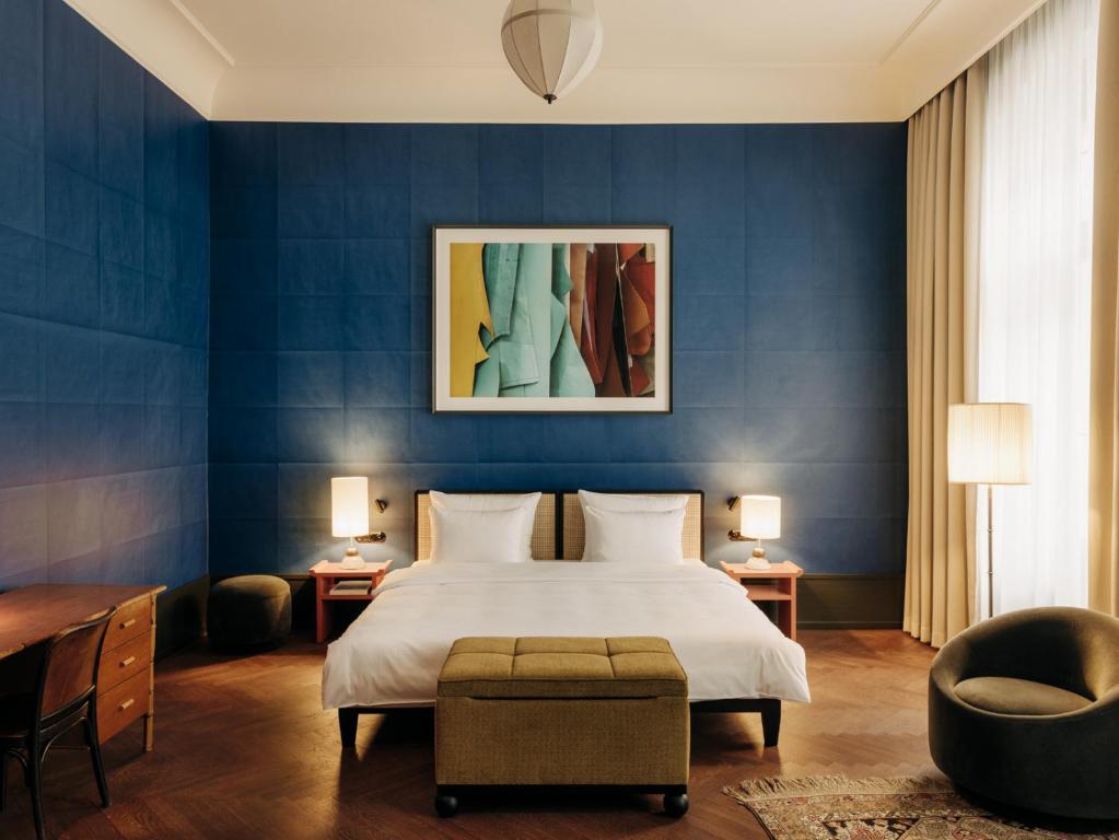ein Schlafzimmer mit einem Bett und einer blauen Wand in der Unterkunft Boutique Hotel Château Royal in Berlin