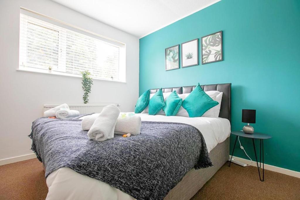 1 dormitorio con 1 cama grande y paredes azules en Emerald House Leisure & Contractors en Peterborough