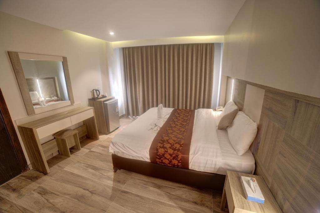 Habitación de hotel con cama y espejo en mass paradise2, en Áqaba