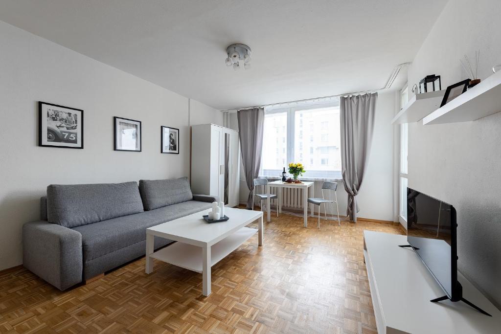 ein Wohnzimmer mit einem Sofa und einem Tisch in der Unterkunft Jagiellońska 4 Prywatne mieszkanie z balkonem i bezpłatnym parkingiem 300m od Stadionu Narodowego in Warschau