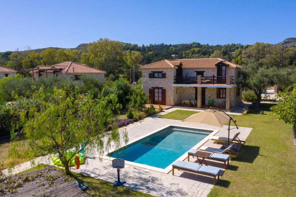 a villa with a swimming pool and a house at Artemis Stone Villa in Vasilikos