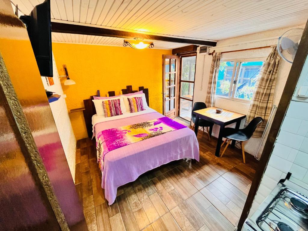 a bedroom with a bed and a table and a window at Altillo Valizas in Barra de Valizas