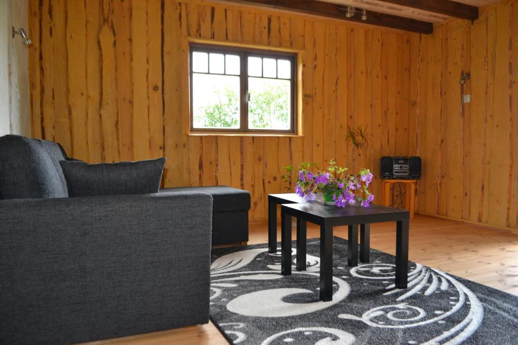 a living room with a couch and a table with flowers at Kivi-Roosi Holiday House in Lümanda