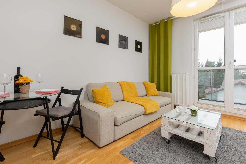 a living room with a couch and a table at Warsaw Bemowo Modern Apartment Dywizjonu 303 by Renters in Warsaw