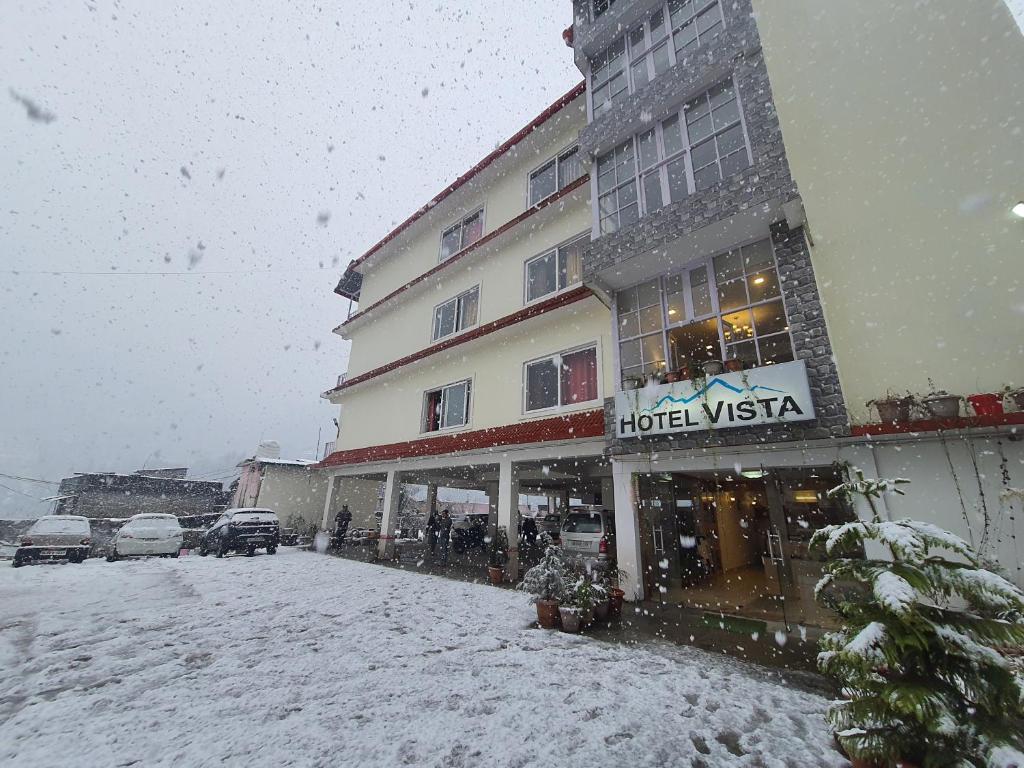 um hotel na neve em frente a um edifício em Hotel Vista Bhowali, Nainital - Vegetarian em Bhowāli