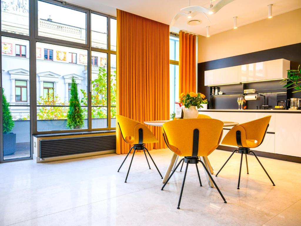 ウッチにあるPietryna Apartments Luxury - Sauna , Jacuzzi , Bezpośrednio przy ul Piotrkowskiejのキッチン(黄色の椅子、テーブル付)