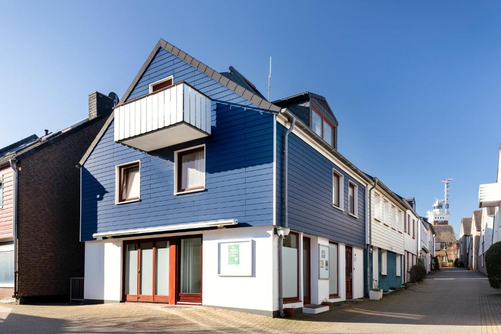 a blue house with a balcony on a street at Haus Hoog Stean in Helgoland