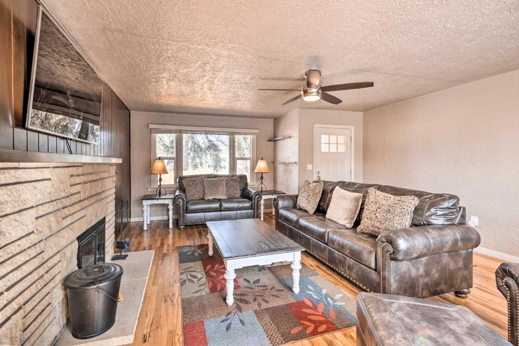 a living room with a leather couch and a fireplace at Colorado Springs Home Game Room, 3 Mi to Downtown in Colorado Springs