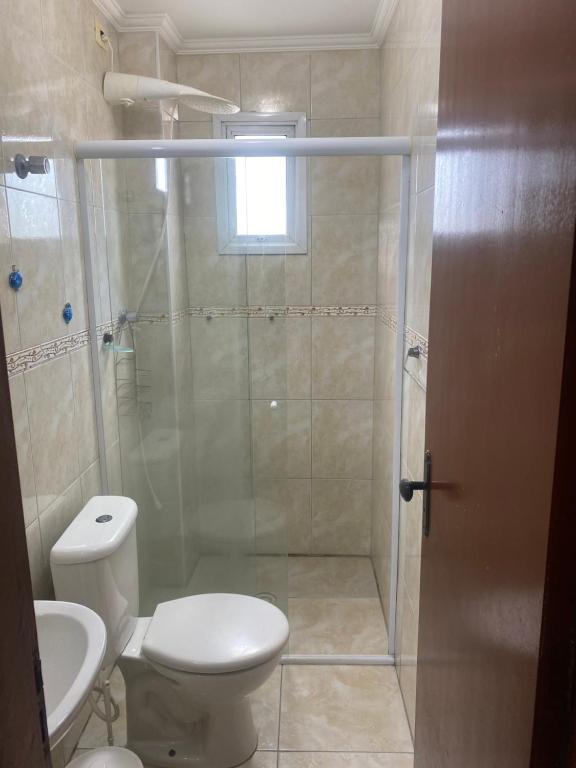 La salle de bains est pourvue d'une douche, de toilettes et d'un lavabo. dans l'établissement Apto a 50m da praia, com ar condicionado, wifi , portaria 24h, à Praia Grande
