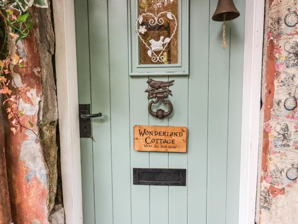 a door with a sign on it with a sign on it at Wonderland Cottage in Cupar