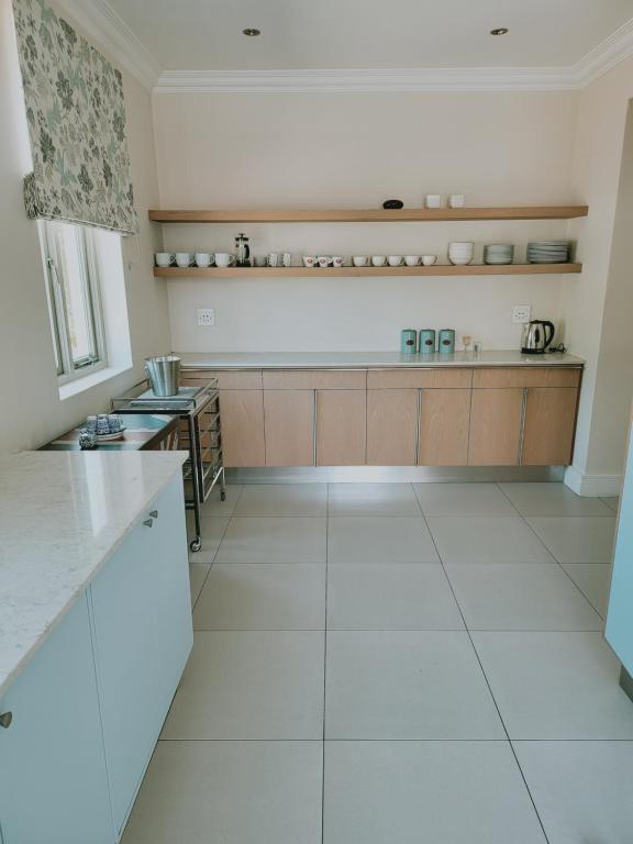 a large kitchen with white tile floors and a counter at The Grandstancia in Cape Town