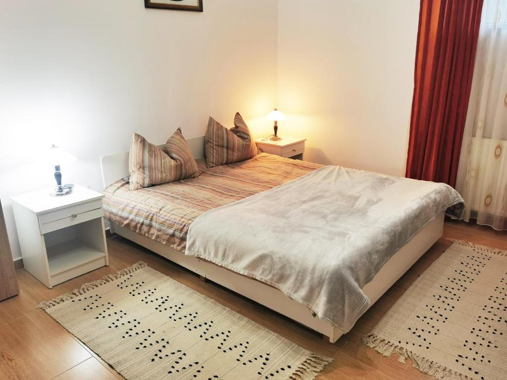 a bedroom with a bed with a night stand and a table at Casa Sabina in Mediaş