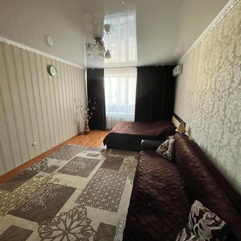 um quarto com 2 camas e um tapete em Однокомнатная в новом районе Жана Кала em Qostanay