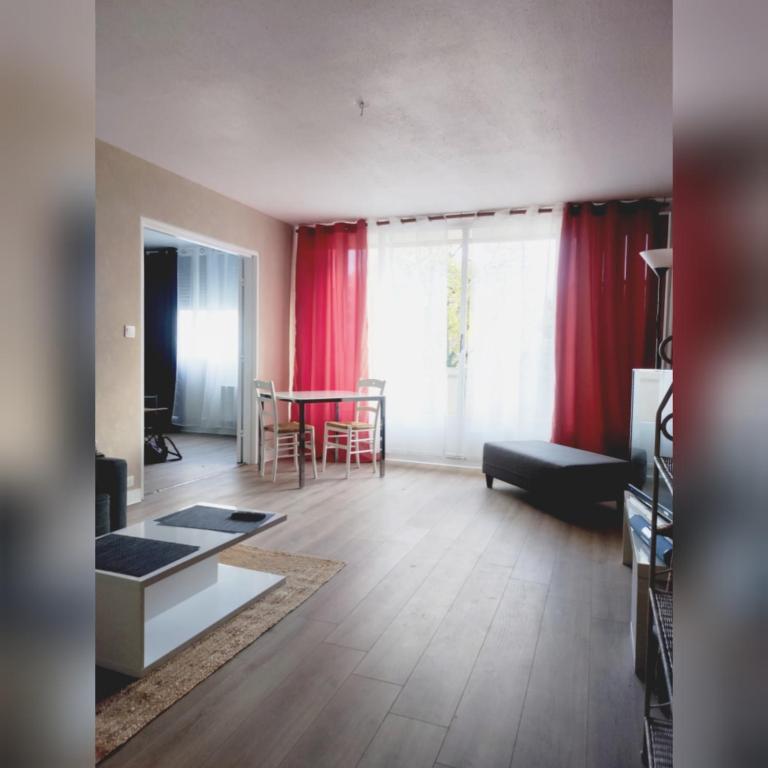 sala de estar con cortinas rojas y mesa en L'appart en Limoges