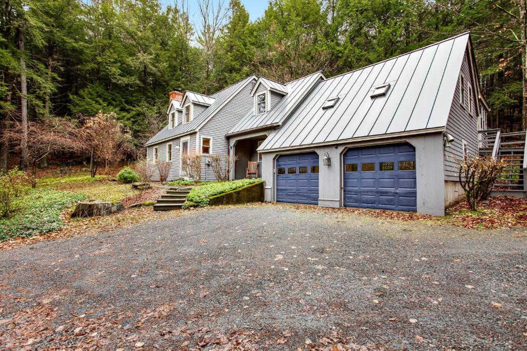 a house with two garage doors on a driveway at Willard Road Hideaway in Quechee