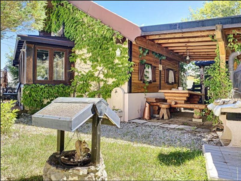 una casa con un alimentador de aves en el patio en Refuge de l'Ecureuil, en Métabief