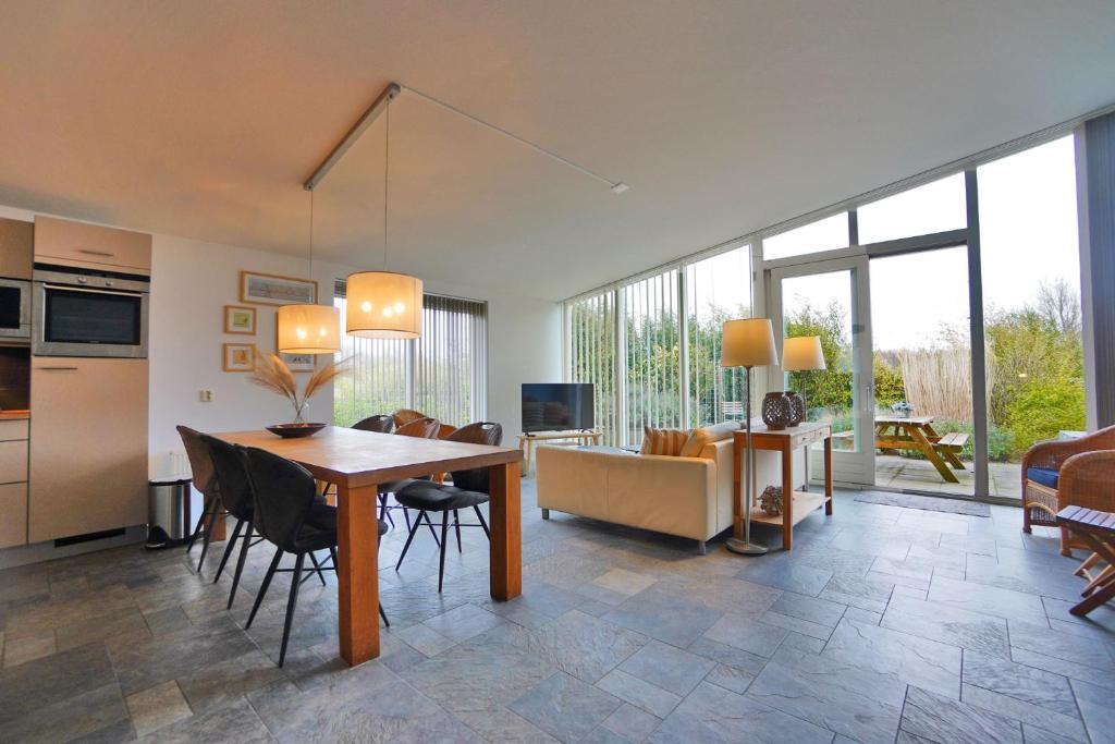 eine Küche und ein Wohnzimmer mit einem Tisch und Stühlen in der Unterkunft Beachlife 9 in Callantsoog