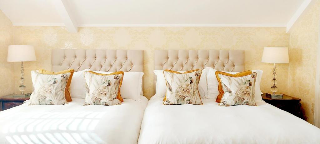 a bedroom with a large white bed with pillows at The Old Schoolhouse of Warren Lodge Boutique Cottages in Dromod