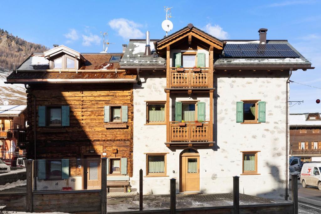 een gebouw met een balkon erboven bij Petalo Rosina's Home in Livigno