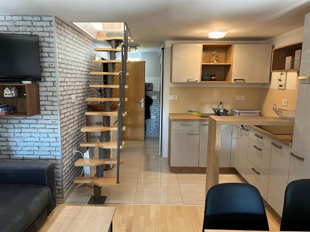 茲雷切的住宿－Apartma GABER 125 - Rogla，一个小房间中的一个厨房和一个螺旋楼梯